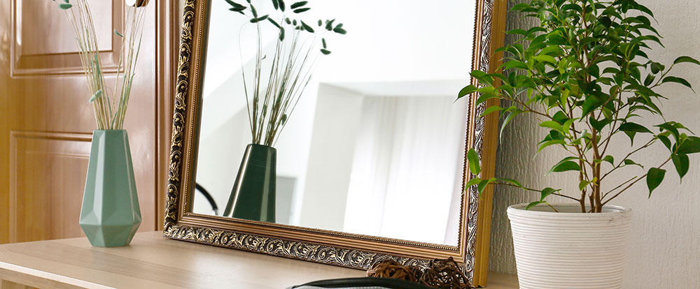 Spejl p&aring; m&aring;l med ramme st&aring;ende p&aring; kommode